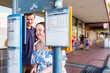 © Austockphoto - Disability worker NDIS provider helping young woman check bus time tables to catch public transport
