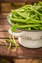 Wall Mural - Healthy and raw green beans in an old white colander.