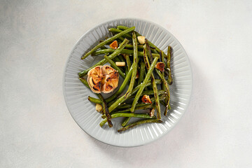 Roasted garlic green beans in grey plate. Top view.