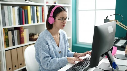 Sticker - Young beautiful hispanic woman student using computer studying at library university