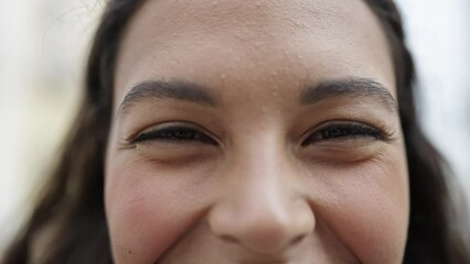 Wall Mural - Young beautiful hispanic woman close up of eyes at street