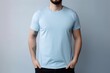 © Tuyres - White man model wearing a plain light blue short sleeved t-shirt, isolated on a blank background. Mock-up, torso only. Generative AI illustration.