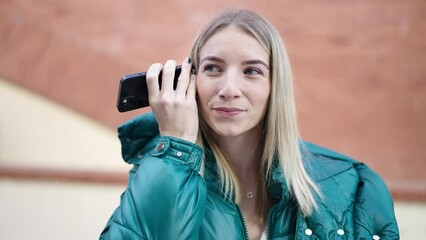 Poster - Young blonde woman listening to voice message at street