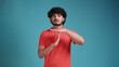 © Виталий Лысак - indian man with beard wearing coral t-shirt isolated on a blue studio background doing time out gesture with hands, frustrated and serious face