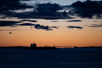 Wall Mural - Silhouette of tanker ships and a bridge in sunset light.