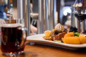 Closeup of fresh meal with garnish served in plate kept in front of wine on table at restaurant, winter holiday travel concept