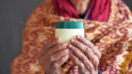 Wall Mural -  elderly woman using petroleum jelly onto skin 