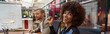 © Kostiantyn - Smiling african businesswoman sitting on his workplace in modern office on colleague background