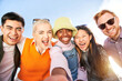 © CarlosBarquero - Smiling selfie of a cheerful group of multicultural friends looking at the camera. Portrait of multi-ethnic youth of diverse races having fun together. Community unity and friendship.