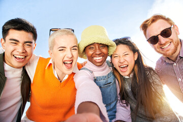 Smiling selfie of a cheerful group of multicultural friends looking at the camera. Portrait of multi-ethnic youth of diverse races having fun together. Community unity and friendship.