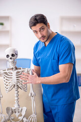 Wall Mural - Young male doctor and skeleton patient at the hospital