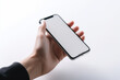 © MVProductions - Top down view of a hand holding a modern smartphone on a white high key background, with copyspace. High quality generative AI