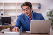 © Elnur - Young male employee working in the office