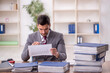 © Elnur - Young male employee and too much work in the office