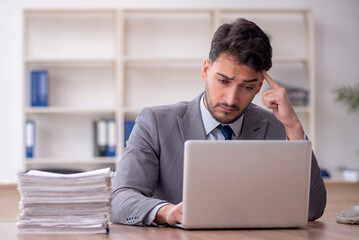 Young male employee and too much work in the office