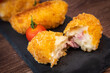 Homemade traditional Spanish croquettes or croquetas on a black plate with fork, Tapas food, High quality photo