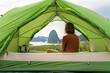 © Cavan Images - Traveler woman sitting inside tent admiring scenery of Phang Nga Bay