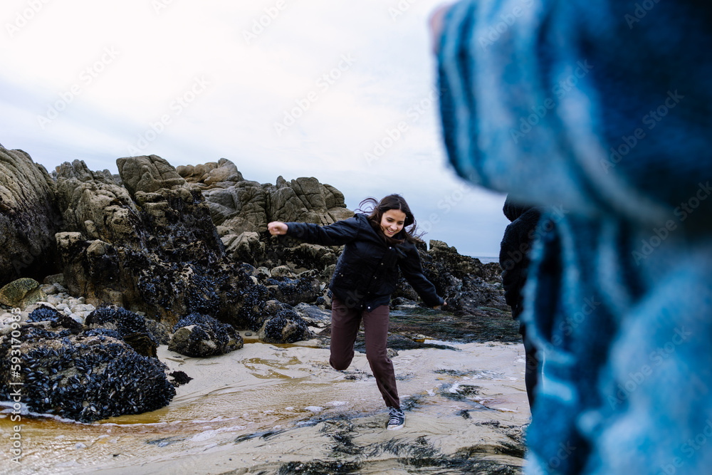 Teen Girl Jumps Over A Stream Of Water At The Beach Stock Photo | Adobe ...