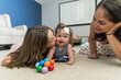 © Cavan Images - big sister playing with special needs sister on floor