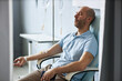 © Seventyfour - Side view portrait of adult man sitting in comfortable chair with IV drip during treatment session and relaxing