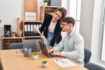 Wall Mural - Young man and woman business workers using laptop working at office