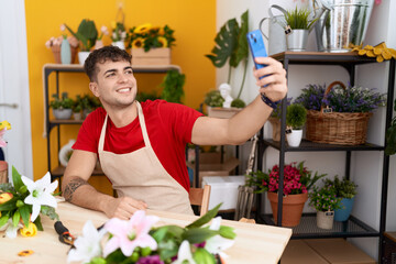 Poster - Young hispanic man florist make selfie by smartphone at flower shop