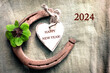 2024 Happy NEW YEAR decoration with four leaf clover and horseshoe with text