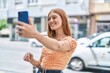 © Krakenimages.com - Young redhead woman smiling confident making selfie by the smartphone at street