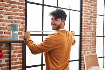 Poster - Young hispanic man smiling confident measuring window at new home