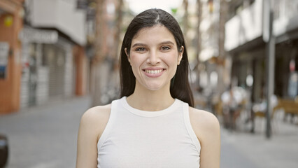 Wall Mural - Young beautiful hispanic woman smiling confident standing at street