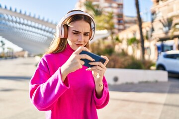 Poster - Young woman playing video game at park