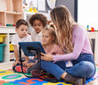 © Krakenimages.com - Woman and group of kids having lesson using touchpad at kindergarten