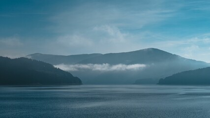 Scenic lake surrounded by mountains and a blue sky