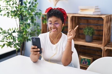 Poster - Young african american woman doing video call with smartphone smiling happy pointing with hand and finger to the side