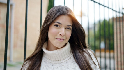 Wall Mural - Young beautiful hispanic woman smiling confident standing at street