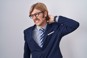 Wall Mural - Caucasian man with mustache wearing business clothes suffering of neck ache injury, touching neck with hand, muscular pain