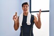 © Krakenimages.com - Hispanic man eating protein bar as healthy energy snack celebrating victory with happy smile and winner expression with raised hands