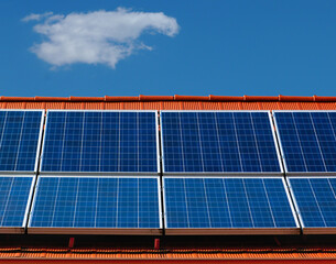 Wall Mural - roof installed photovoltaic PV sun collector solar panels. clear blue sky red clay sloped residential roof in daylight. alternative and clean energy generation. self sufficiency and off grid concept.