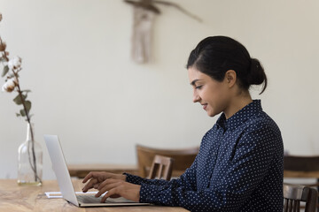 Canvas Print - Pretty young Indian woman freelancer working on computer at home, studying on-line, using new software, web surfing helpful information, shopping through internet webstore. Workflow using modern tech