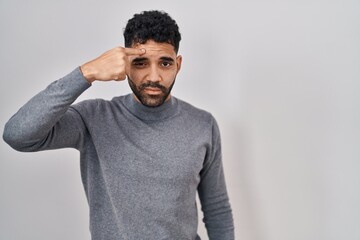 Poster - Hispanic man with beard standing over white background pointing unhappy to pimple on forehead, ugly infection of blackhead. acne and skin problem