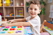 © Krakenimages.com - Adorable caucasian boy playing with maths puzzle game sitting on table at kindergarten