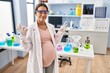© Krakenimages.com - Young pregnant woman working at scientist laboratory relax and smiling with eyes closed doing meditation gesture with fingers. yoga concept.