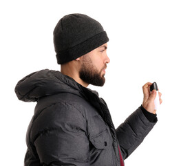 Young man with pepper spray for self-defence on white background