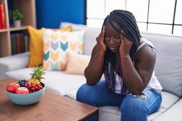 Poster - African american woman stressed sitting on sofa at home