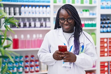 Poster - African american woman pharmacist using smartphone working at pharmacy