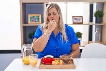 Canvas Print - Caucasian plus size woman eating breakfast at home feeling unwell and coughing as symptom for cold or bronchitis. health care concept.