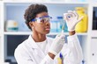 © Krakenimages.com - African american woman wearing scientist uniform holding vaccine at laboratory