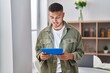 © Krakenimages.com - Young hispanic man using touchpad standing at home