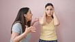 © Krakenimages.com - Two women covering ears with hands arguing over isolated pink background