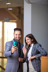 Wall Mural - Young Businessman showing some detail in smartphone to his female secretary at office.